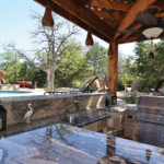 A shaded outdoor kitchen with all the amenities.