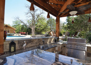 A shaded outdoor kitchen with all the amenities.