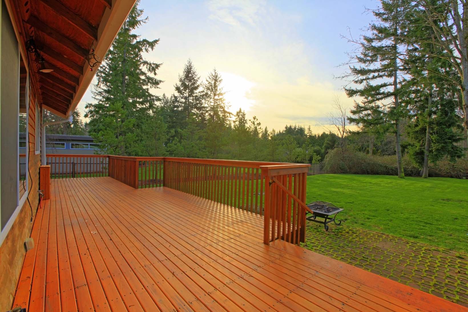 A gorgeous wooden deck overlooking a large yard.