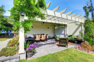 A paver patio shaded by a pergola.