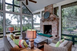 Luxurious three season screen porch with fireplace, looking out onto waterfront property