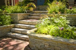 A paved walkway in a beautiful yard.