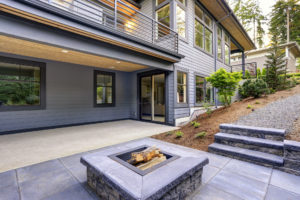 A modern home with a patio featuring a fire pit.