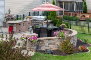 An attractive paved patio with grill and custom retaining walls.