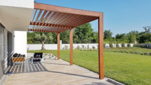 A modern patio is shaded with help from a custom pergola.