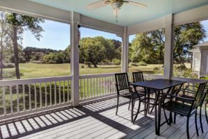 Three season screen porch with view out onto golf course and park.