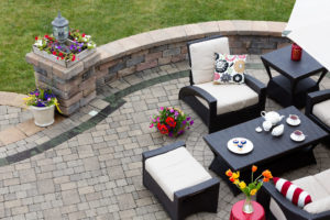 An attractive paved patio with furniture and custom retaining wall..