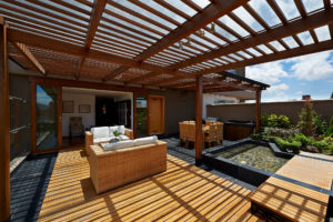 A modern patio is shaded with help from a custom pergola